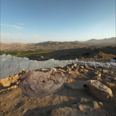 The view of Ararat Plain Southeast Archaeological Project site from within the MR headset, where both a grey stone wall and a brown pottery vessel are virtually visible in their original positions, even though they were actually removed a year earlier. (Photo credit: HKU Faculty of Arts)